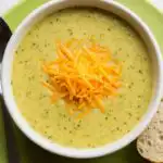 Creamy broccoli cheese soup served hot in a rustic bowl with melted cheddar on top