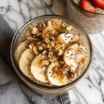 Brown Sugar Overnight Oats in a bowl topped with sliced bananas, chopped walnuts, cinnamon, and brown sugar for an easy healthy breakfast.